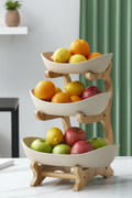 3-tier bamboo fruit stand with cream bowls on marble counter with fresh fruits