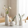 Set of 4 white ceramic vases styled on marble table with dried flowers