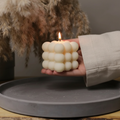 Hand holding cream bubble soy candle